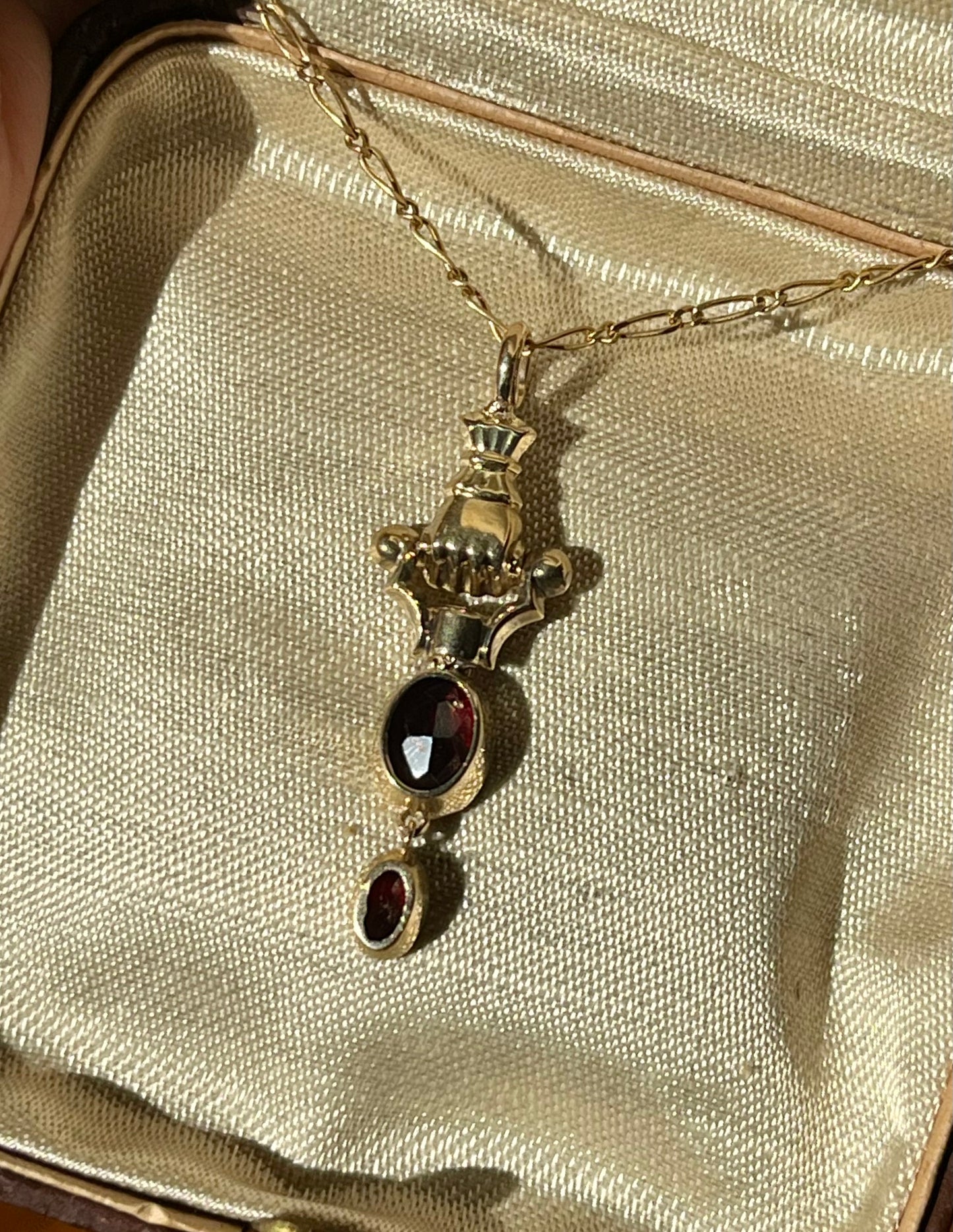 Gold Hand and garnet pendant